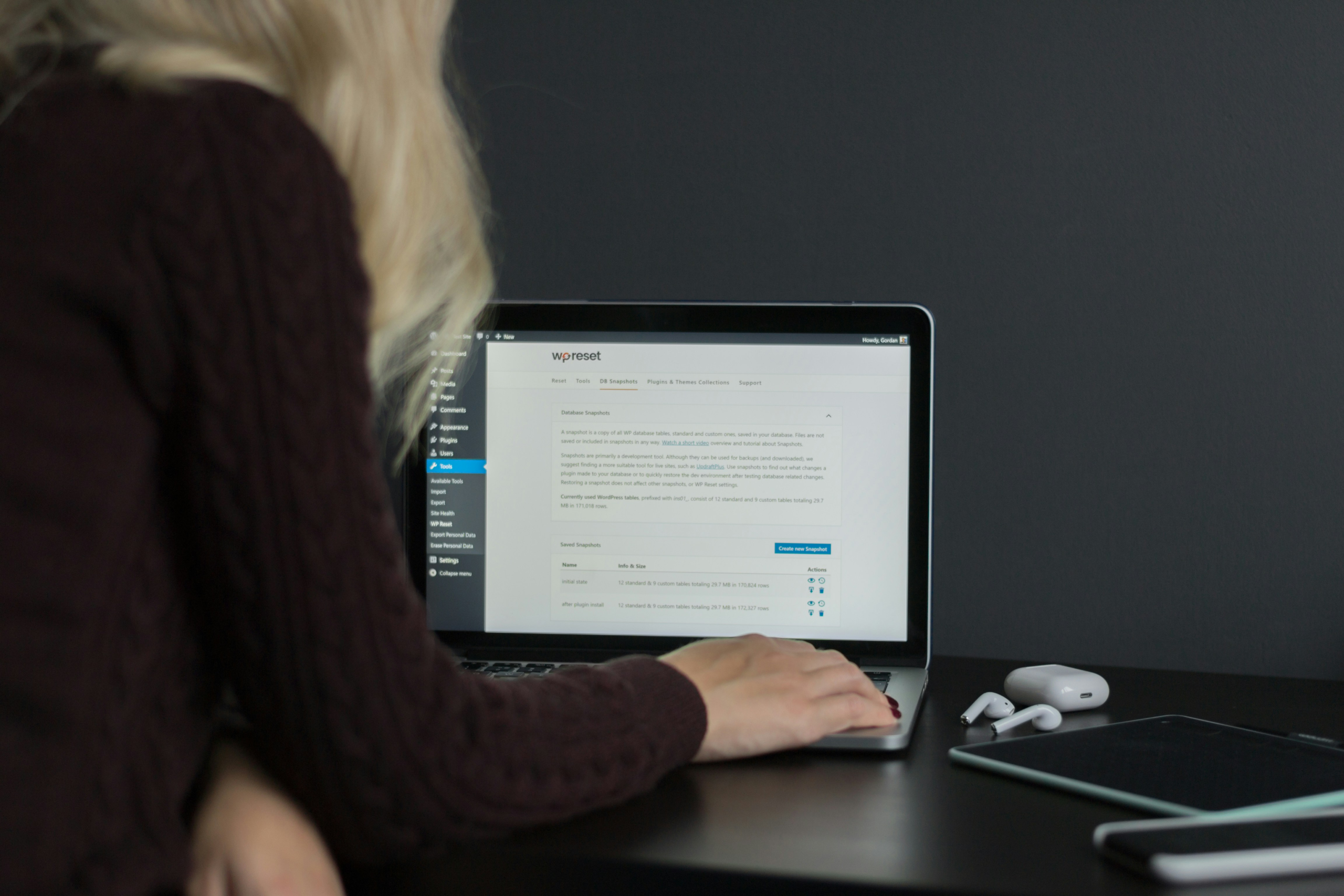 Blonde woman working on a laptop with a WordPress dashboard